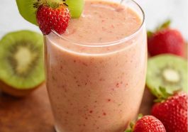 Refreshing strawberry‑kiwi smoothie served in a glass, garnished with fresh fruit slices and a sprig of mint.