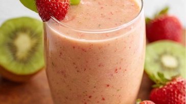 Refreshing strawberry‑kiwi smoothie served in a glass, garnished with fresh fruit slices and a sprig of mint.
