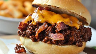 Bacon, beer, and cheese sloppy joes served on toasted buns with melted cheese and crispy bacon pieces.