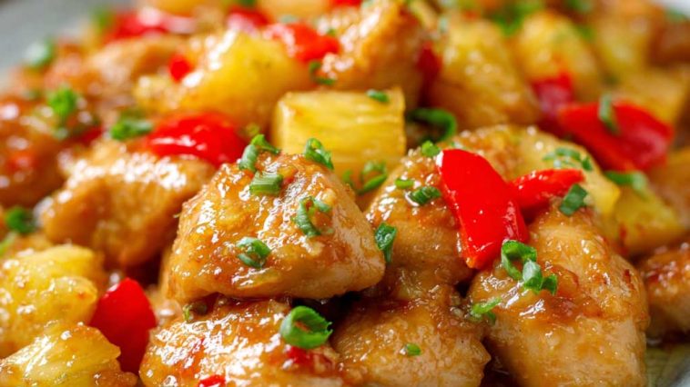 Brown sugar pineapple chicken baked with juicy pineapple chunks, caramelized glaze, and garnished with fresh herbs.
