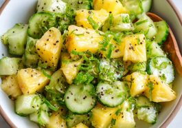 Pineapple cucumber salad with fresh herbs in a bowl