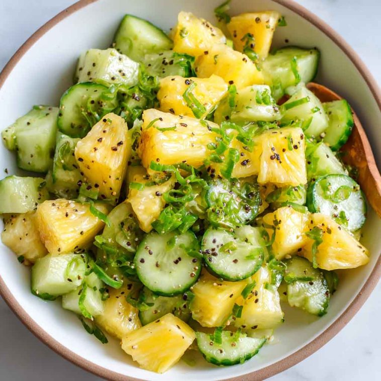 Pineapple cucumber salad with fresh herbs in a bowl