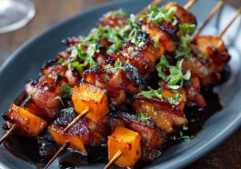 Candied sweet potato and bacon skewers glazed with a sticky brown sugar sauce, roasted until caramelized and crispy, served on wooden skewers.