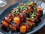 Candied sweet potato and bacon skewers glazed with a sticky brown sugar sauce, roasted until caramelized and crispy, served on wooden skewers.