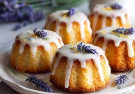 Mini lemon cakes topped with a delicate lavender glaze, soft and moist with a light floral finish, served on a dessert plate.