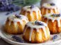 Mini lemon cakes topped with a delicate lavender glaze, soft and moist with a light floral finish, served on a dessert plate.