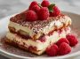 Fresh raspberry tiramisu layered with mascarpone cream, ladyfingers, and vibrant raspberries in a glass dish