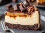 Decadent caramel brownie cheesecake topped with rich caramel drizzle and chocolate chunks, served on a dessert plate.