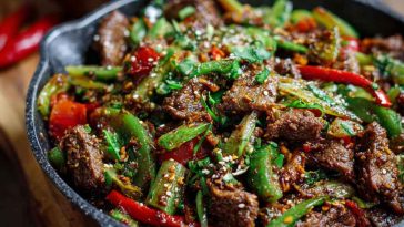 Spicy cumin lamb stir fry with peppers and onions in a wok