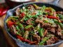Spicy cumin lamb stir fry with peppers and onions in a wok