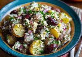 Colorful olive Greek potato salad with red potatoes, Kalamata olives, cucumbers, tomatoes, and feta cheese tossed in lemon‑herb dressing.