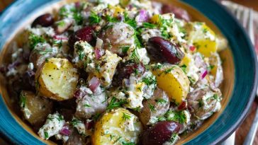 Colorful olive Greek potato salad with red potatoes, Kalamata olives, cucumbers, tomatoes, and feta cheese tossed in lemon‑herb dressing.
