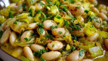 Flavorful butter beans with sautéed leeks served in a rustic bowl, garnished with fresh herbs and olive oil.