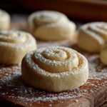 Freshly baked lemon rolls drizzled with sweet glaze, arranged on a plate with lemon slices.