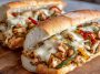 Ultimate Chicken Philly Cheese Steaks Recipe with juicy sliced chicken, sautéed onions and peppers, melted cheese, served in toasted hoagie rolls.