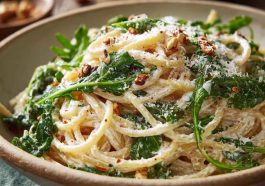 Creamy lemon ricotta pasta with fresh arugula, inspired by Stanley Tucci, served in a bowl with a light, zesty sauce and grated cheese.