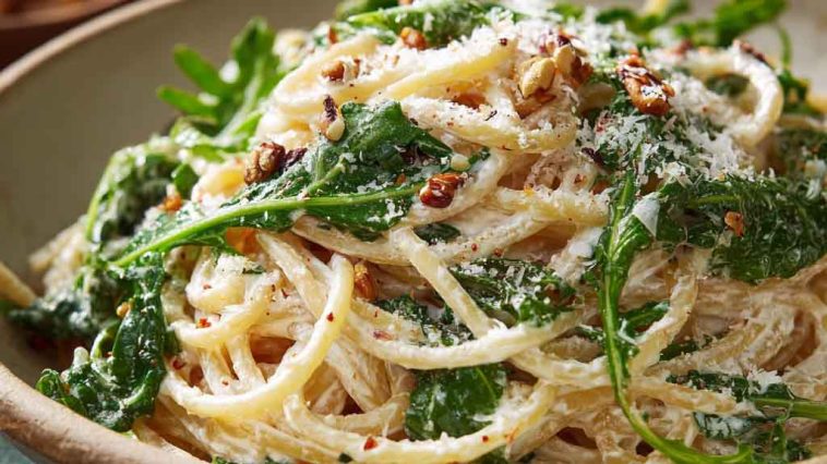 Creamy lemon ricotta pasta with fresh arugula, inspired by Stanley Tucci, served in a bowl with a light, zesty sauce and grated cheese.