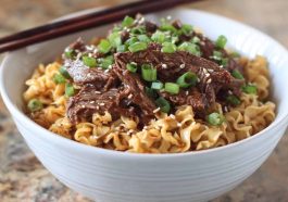 "Bowl of Korean beef noodles with tender beef slices, vegetables, and sesame seeds in a savory sauce"
