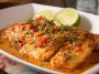 Pan-seared tilapia fillets served with vibrant roasted red pepper sauce and fresh herbs.