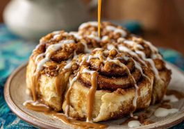Freshly baked cinnamon rolls drizzled with icing, swirled with Biscoff cookie butter filling, and topped with crushed Biscoff cookies.