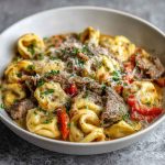 Creamy crock pot cheesesteak tortellini with tender beef, melted cheese, and tender pasta in a savory sauce.