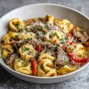 Creamy crock pot cheesesteak tortellini with tender beef, melted cheese, and tender pasta in a savory sauce.