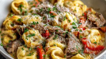 Creamy crock pot cheesesteak tortellini with tender beef, melted cheese, and tender pasta in a savory sauce.
