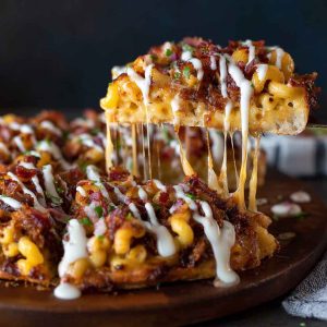 “A BBQ pulled pork pizza topped with creamy mac ’n’ cheese, crispy bacon, and melted cheese on a golden crust.”