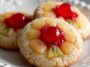 Golden pineapple upside down sugar cookie topped with caramelized pineapple rings and cherries on a dessert plate