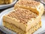 Moist peanut butter sheet cake topped with creamy peanut butter frosting, sliced into squares and served on a tray.