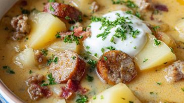 Classic German potato soup with sausage, carrots, celery, and herbs served in a rustic bowl.