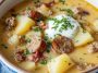 Classic German potato soup with sausage, carrots, celery, and herbs served in a rustic bowl.