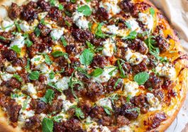 Sweet & spicy sausage ricotta honey pizza topped with fresh basil, melted cheese, and a drizzle of golden honey.