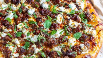 Sweet & spicy sausage ricotta honey pizza topped with fresh basil, melted cheese, and a drizzle of golden honey.