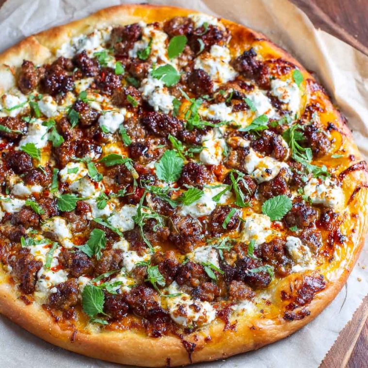 Sweet & spicy sausage ricotta honey pizza topped with fresh basil, melted cheese, and a drizzle of golden honey.