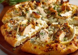 A golden-brown roasted garlic white chicken pizza topped with melted mozzarella, tender chicken pieces, and fresh herbs on a crispy crust.