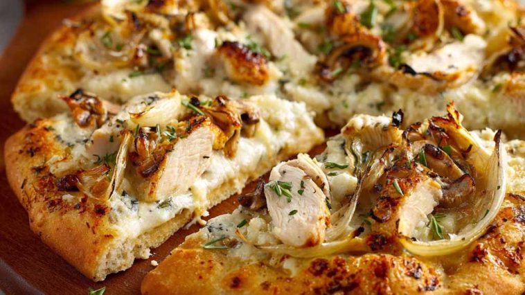 A golden-brown roasted garlic white chicken pizza topped with melted mozzarella, tender chicken pieces, and fresh herbs on a crispy crust.