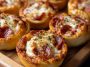 Mini deep dish pizzas made with crescent roll dough, filled with melted cheese, tomato sauce, and pepperoni, served in a muffin tin.