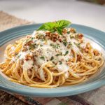 Cream Cheese Spaghetti with creamy sauce, garnished with fresh herbs and parmesan, served in a white bowl.