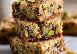 Golden brown butter pistachio cookie bars drizzled with honey and topped with chopped pistachios.