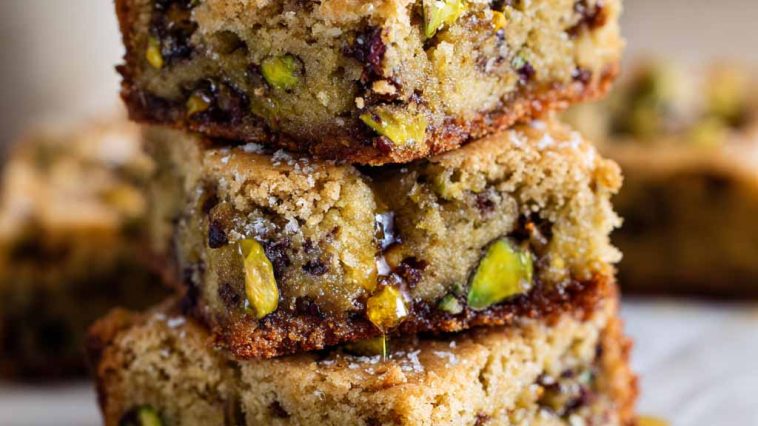 Golden brown butter pistachio cookie bars drizzled with honey and topped with chopped pistachios.