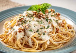 Cream Cheese Spaghetti with creamy sauce, garnished with fresh herbs and parmesan, served in a white bowl.