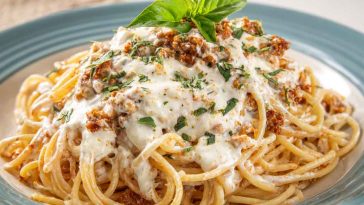 Cream Cheese Spaghetti with creamy sauce, garnished with fresh herbs and parmesan, served in a white bowl.