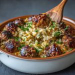 Honey garlic meatball rice bake in a casserole dish with parsley garnish