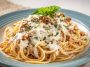 Cream Cheese Spaghetti with creamy sauce, garnished with fresh herbs and parmesan, served in a white bowl.