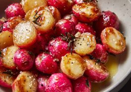 A tray of roasted radishes glistening with melted butter and sprinkled with flaky sea salt, served warm.