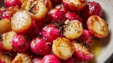 A tray of roasted radishes glistening with melted butter and sprinkled with flaky sea salt, served warm.