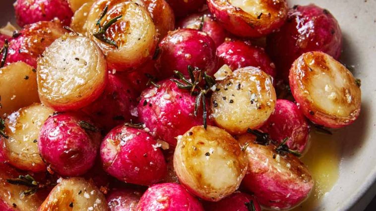 A tray of roasted radishes glistening with melted butter and sprinkled with flaky sea salt, served warm.