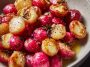 A tray of roasted radishes glistening with melted butter and sprinkled with flaky sea salt, served warm.
