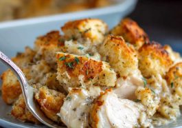 Golden baked chicken with savory stuffing, served hot in a casserole dish, garnished with fresh herbs.